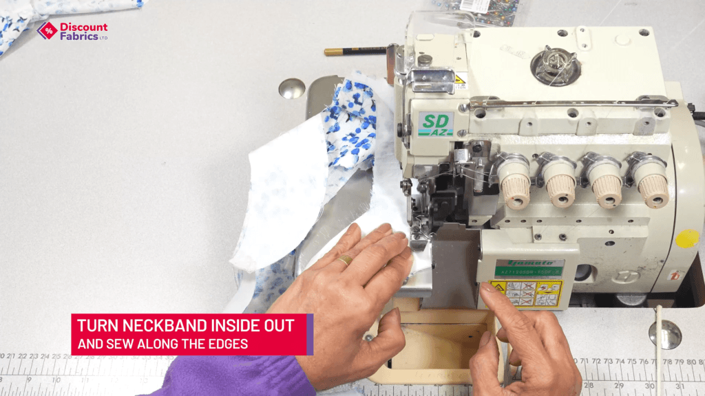 A person sewing a blue-patterned fabric using a serger machine. A bright pink text box in the bottom left corner reads: